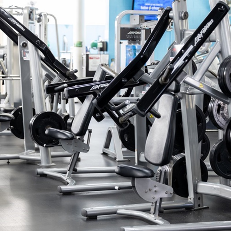 A photo of different gym machines and equipment spread out in a large room