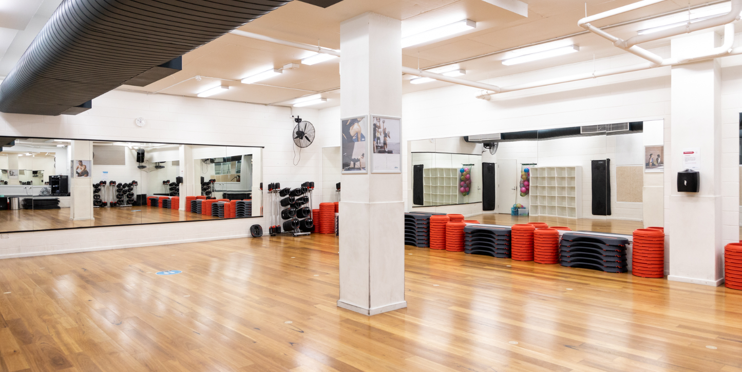 A photo of a spacious active area with balance boards, weights and a full wall mirror in the background